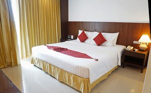 A hotel room with a large bed, a nightstand with a lamp, and a wooden headboard. - iCheck inn Mayfair Pratunam (Bangkok)