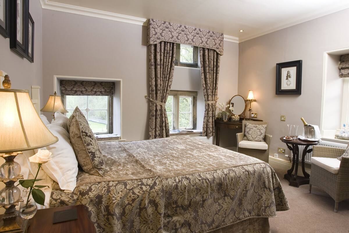 Une chambre à coucher avec un grand lit, une table de chevet avec une lampe, une chaise et une commode.
