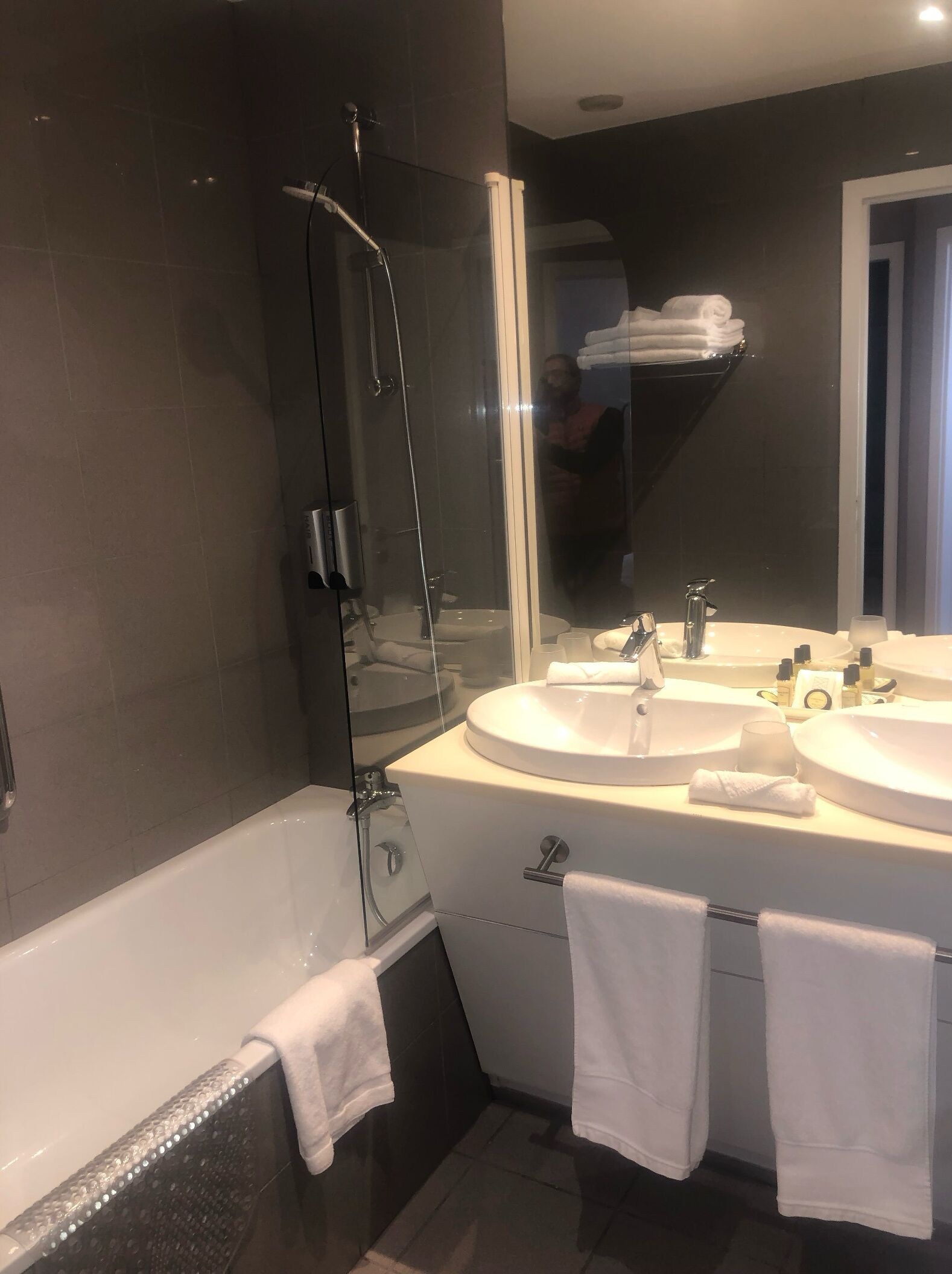 A modern bathroom with a glass-enclosed shower, two sinks, and a large mirror.