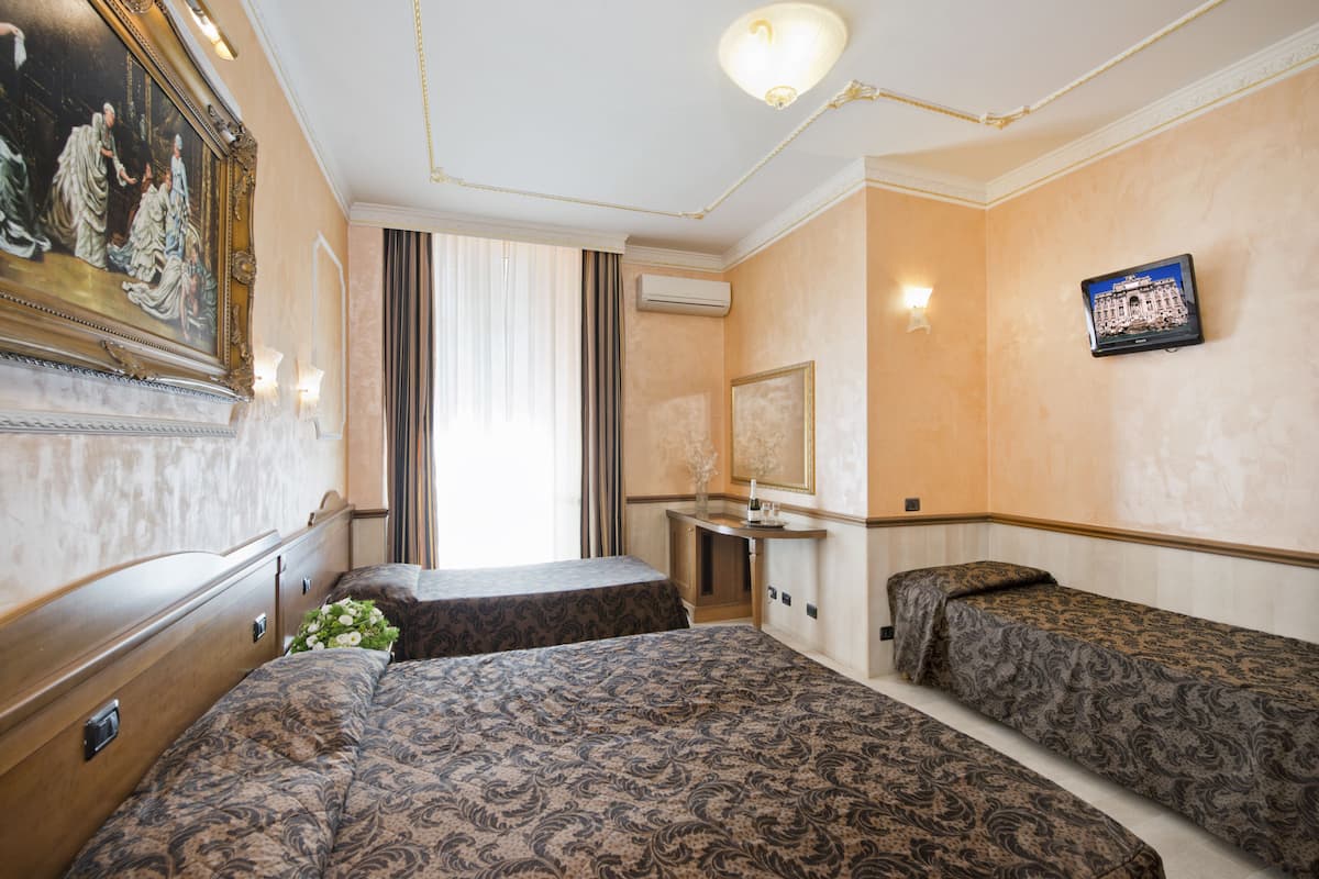 A hotel room with two beds, a desk, a mirror, and a painting on the wall.