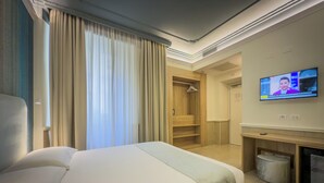 A hotel room with a bed, a TV, a wardrobe, and a bathroom. - Hotel Marco Polo (Rome)