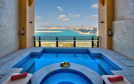 A pool with a city view, a lounge area, and a balcony with a railing.