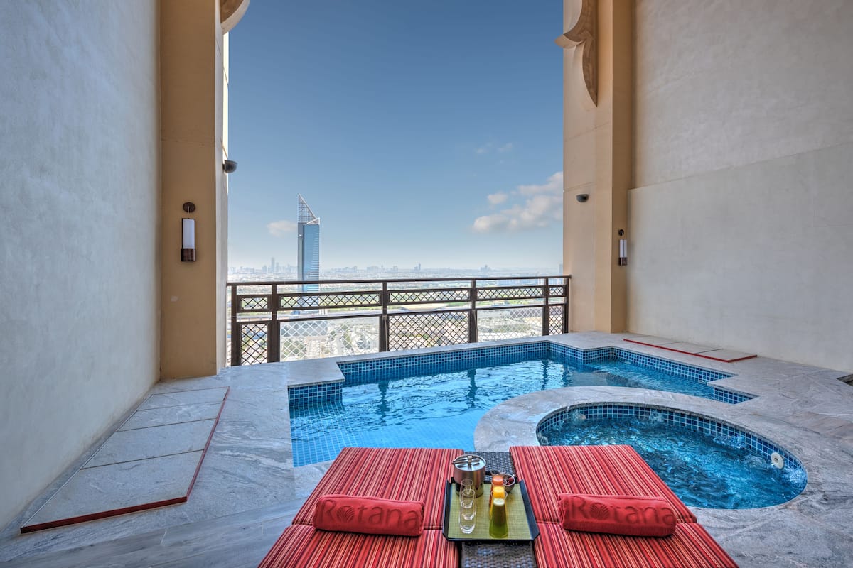 A rooftop pool with a view of a city skyline, including a tall building.