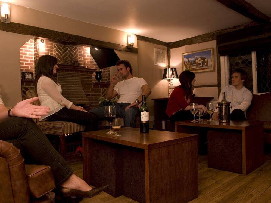 A cozy living room with a brick fireplace, wooden furniture, and a warm ambiance.