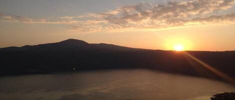 A sunset over a lake with mountains in the background.