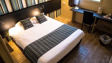 Ein Hotelzimmer mit einem großen Bett, einem Schreibtisch und einem Stuhl.