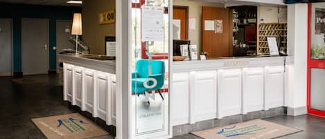 A reception area with a counter, a blue chair, and a sign that reads "RECEPTION".