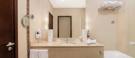 A modern bathroom with a sink, mirror, towel rack, and a shower area.