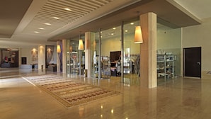 A spacious lobby with a polished marble floor, a large patterned rug, and a boutique store with glass display cases. - Atlas Essaouira Riad Resort (Essaouira)