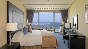 A hotel room with a large bed, a desk, a chair, and a view of the ocean. - Atlas Essaouira Riad Resort (Essaouira)