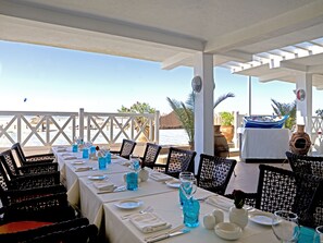 A dining area with a table set for four, overlooking the sea. - Atlas Essaouira Riad Resort (Essaouira)