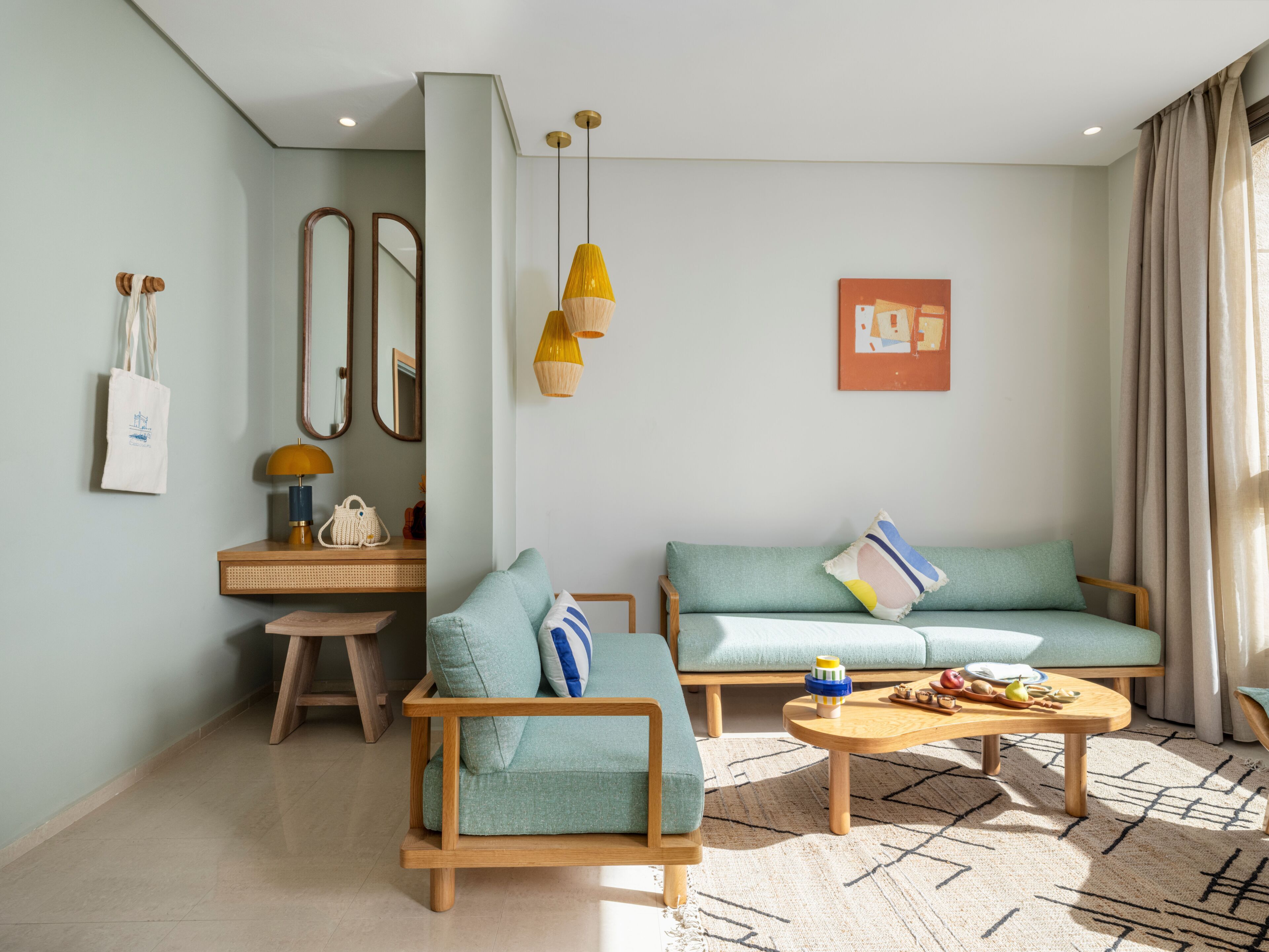 Una sala moderna con sofá, sillón, mesa de centro y una pequeña mesita de madera.