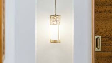 Un interno moderno con una lampada a sospensione e una porta in legno decorata con un motivo geometrico.