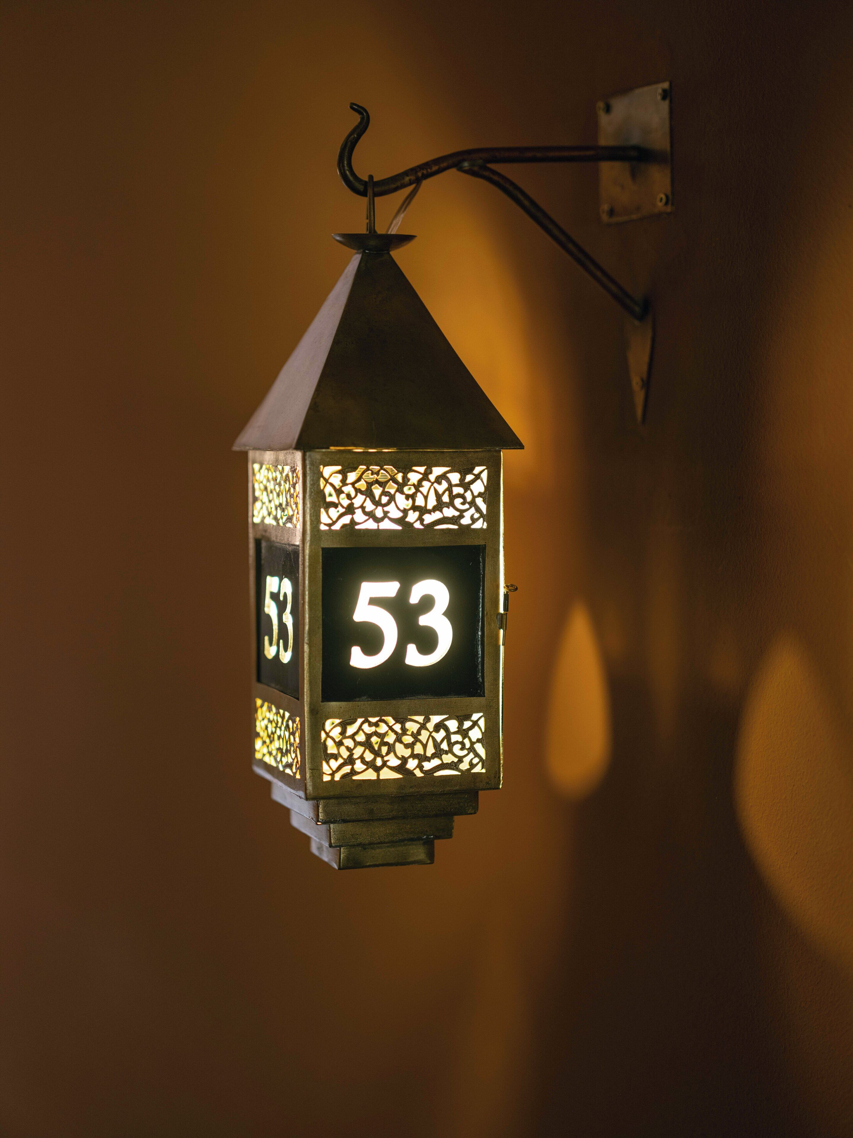 A wall-mounted lantern with the number 53.
