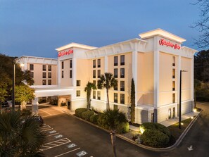 Un hotel con entrada accesible, aparcamiento con plazas para discapacitados y fachada bien iluminada.