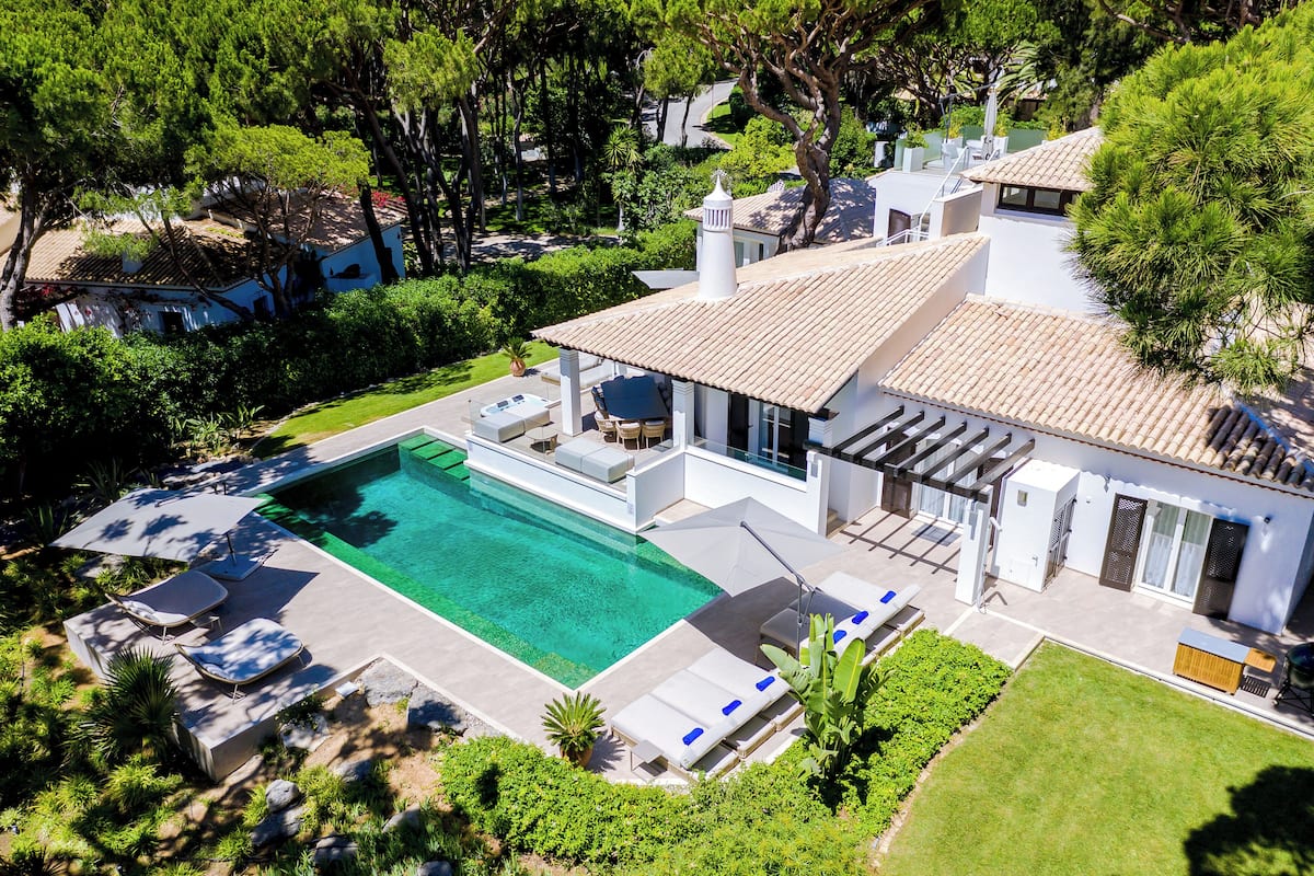 A modern house with a swimming pool, outdoor seating, and a well-maintained garden.