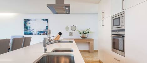 A modern kitchen with a central island, stainless steel appliances, and a minimalist design.