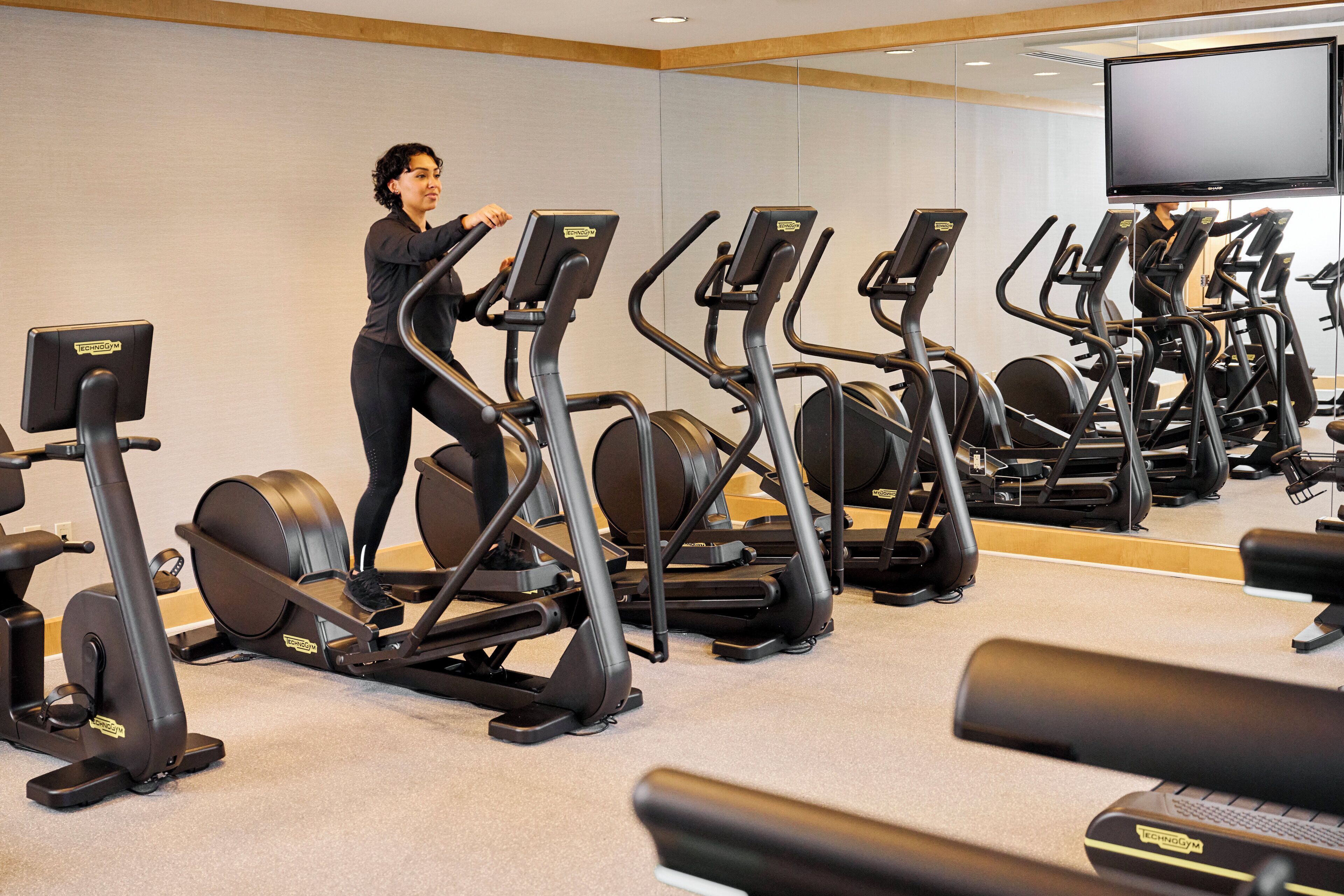 Un gimnasio con cintas de correr y equipo de ejercicio.
