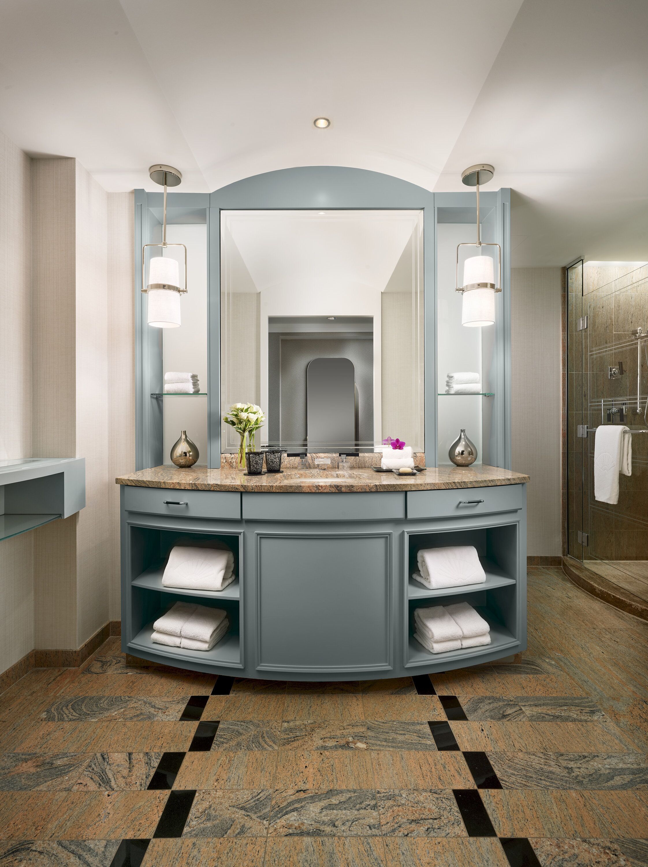 Une salle de bain moderne avec un grand miroir, deux lavabos et un espace douche.