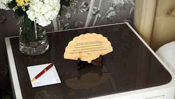 En träplatta på ett glasbord, tillsammans med en röd penna och ett pappersark.