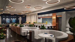 A modern restaurant with round tables, white cushioned seating, and circular ceiling lights. - Mandarin Oriental, Boston (Boston)