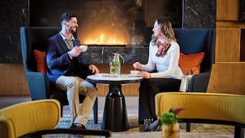 A couple seated at a round table with a fireplace in the background.