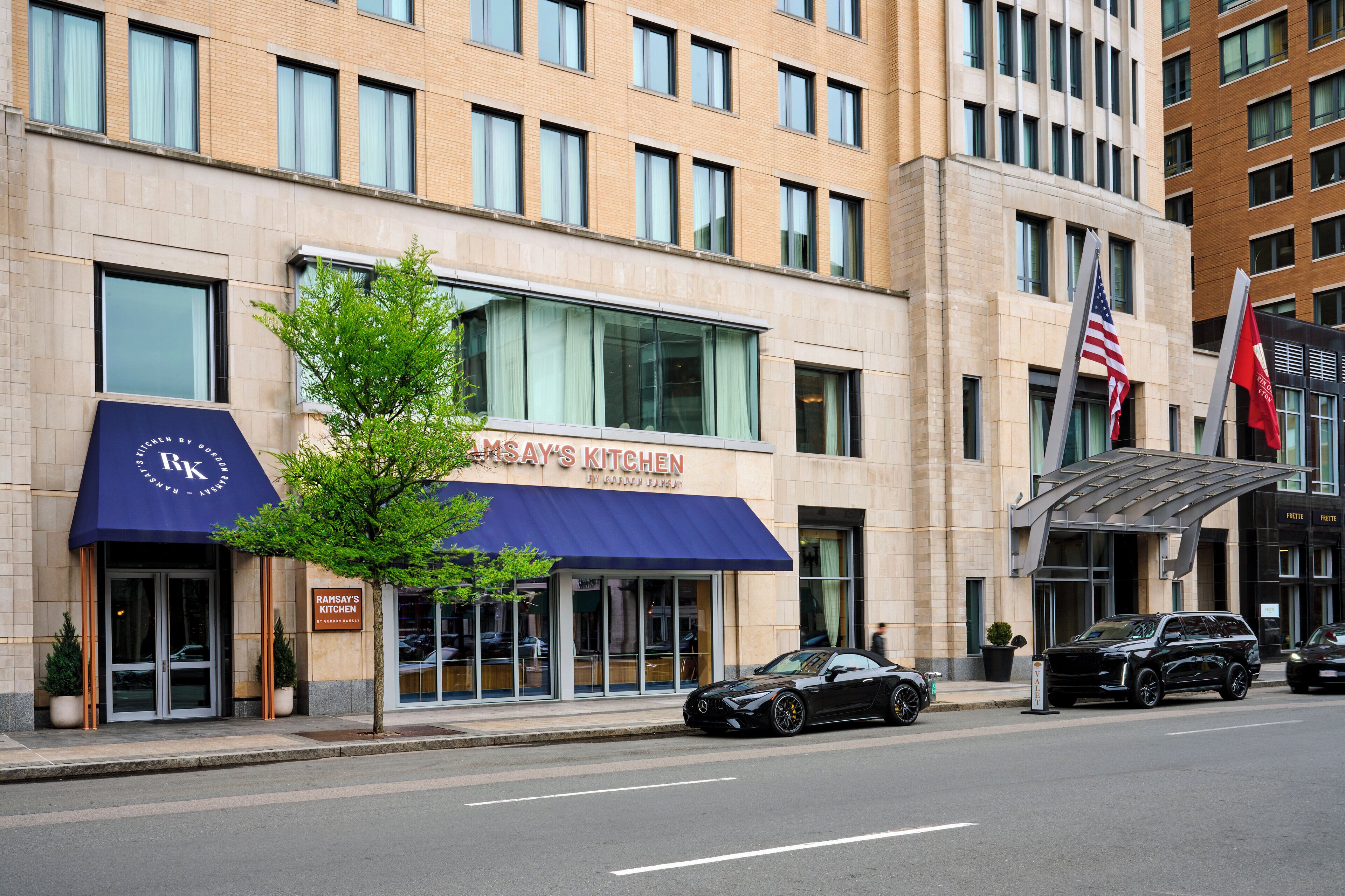 A building with a restaurant named "Rahn's Kitchen" and a parking area with cars.