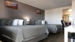 Een hotelkamer met twee bedden, een bureau en een stoel.