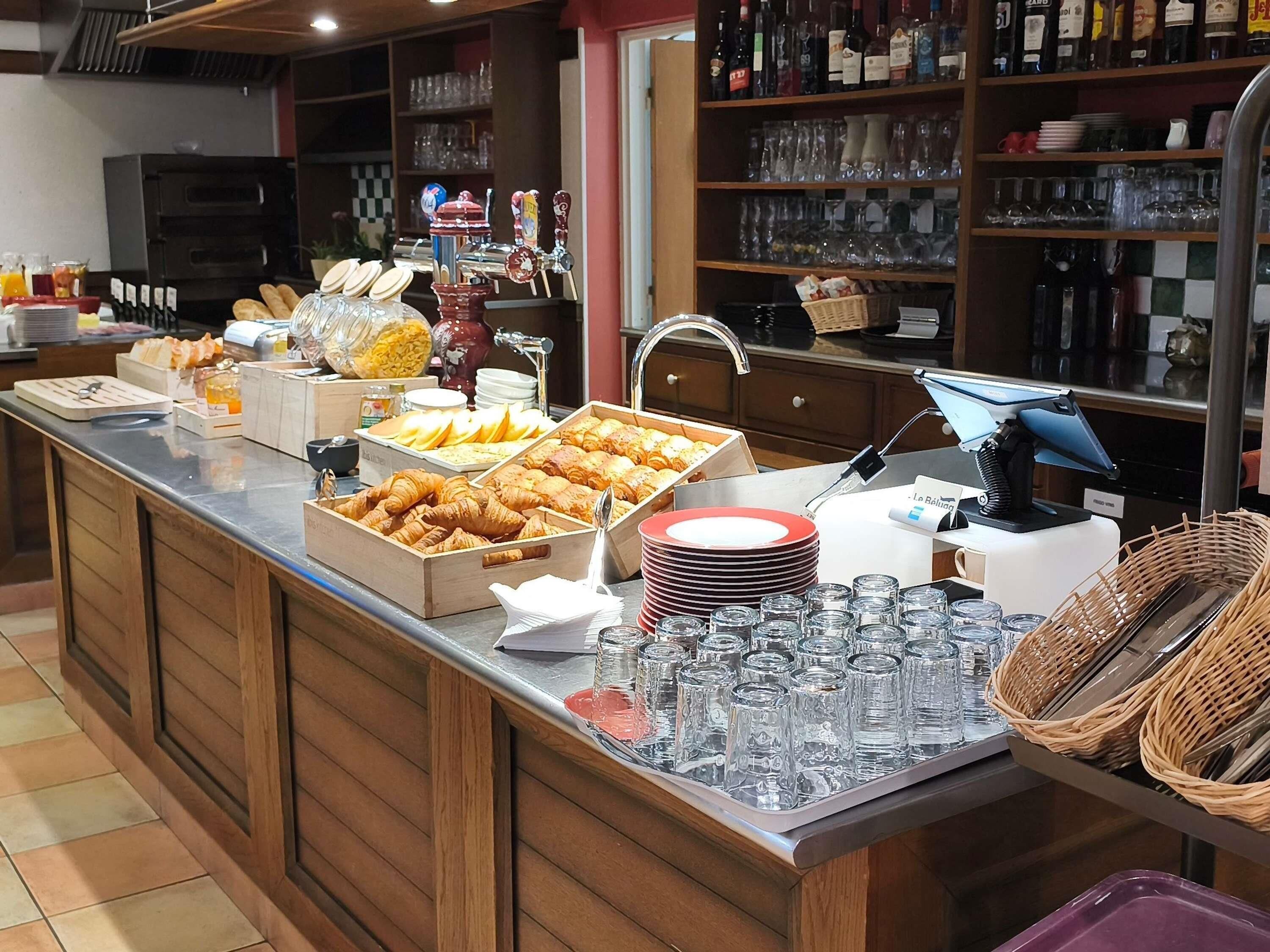 Ein Buffet mit verschiedenen Speisen, Gläsern und einer Kaffeemaschine.