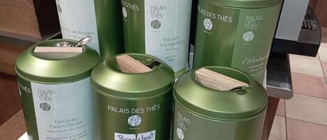 Una exhibición de latas de té verde con etiquetas que indican distintos sabores y orígenes.