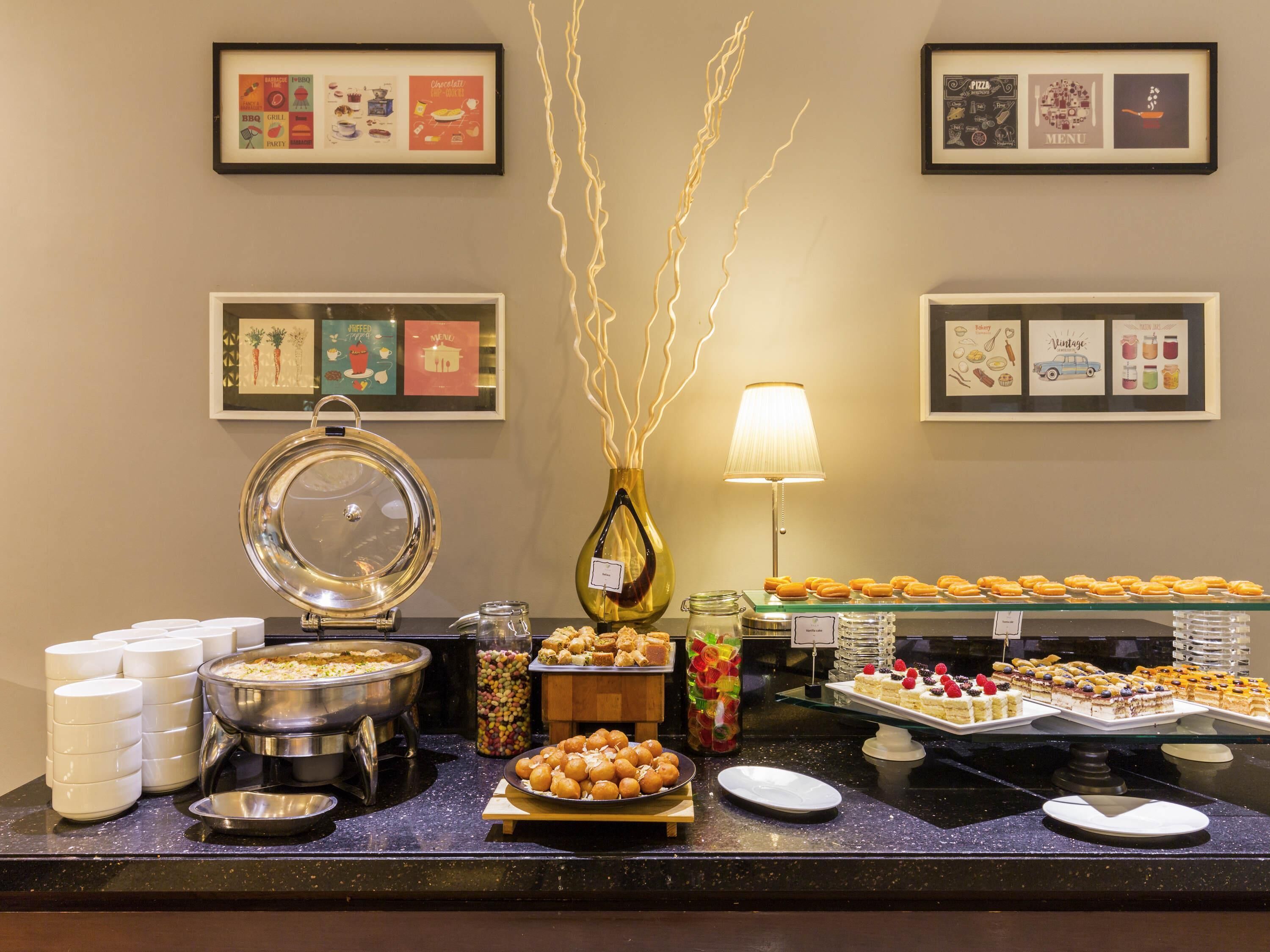A buffet setup with various food items and a decorative vase.