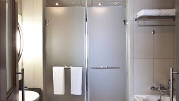 A modern bathroom with a glass-enclosed shower, a sink, and a bathtub.