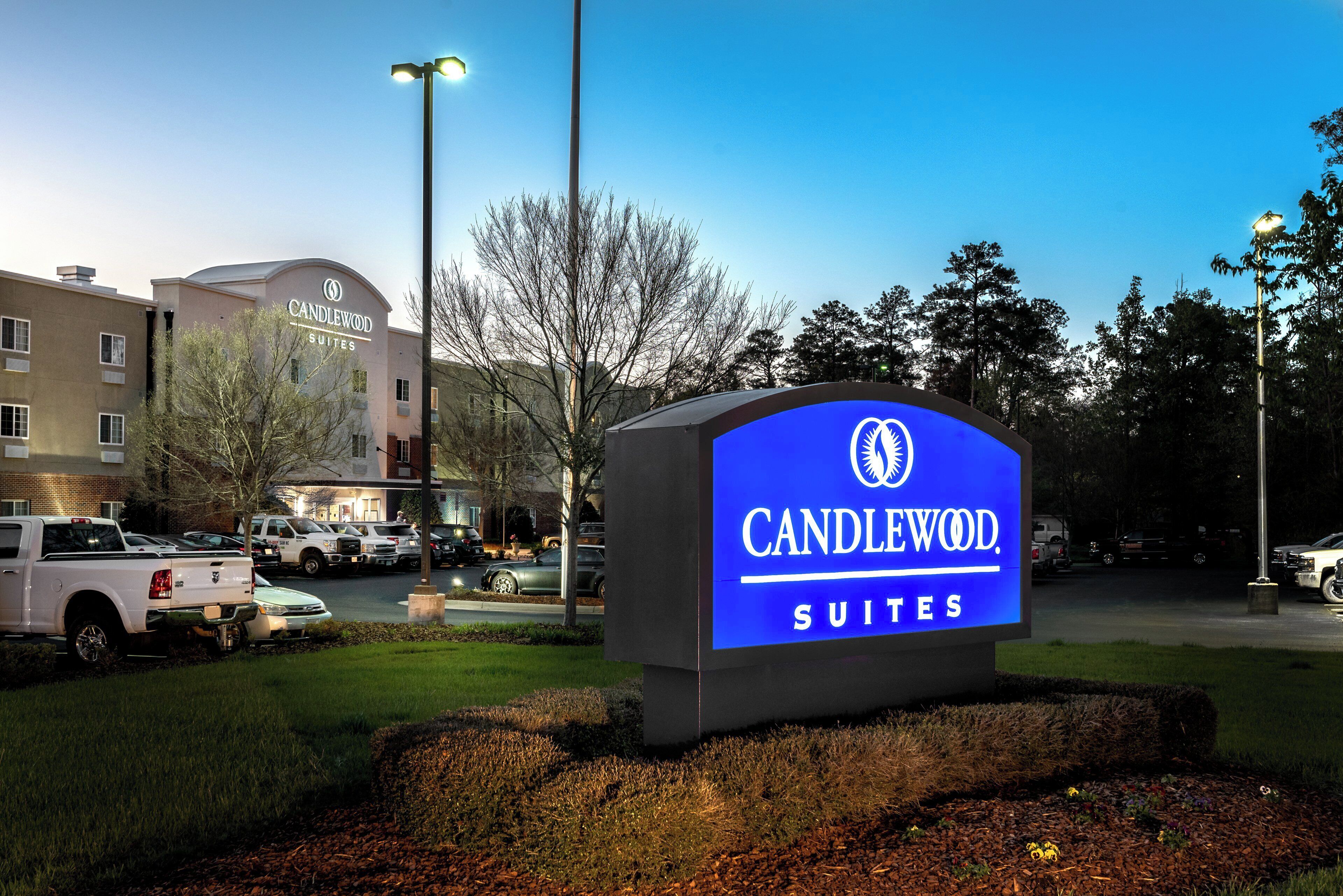 A hotel sign with the name 'CANDLEWOOD SUITES' and a building in the background.