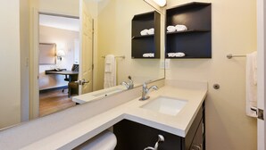A modern bathroom with a double sink, a large mirror, and a towel rack.