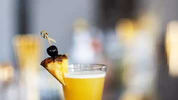 Un cóctel con una rodaja de piña en una copa de tallo.
