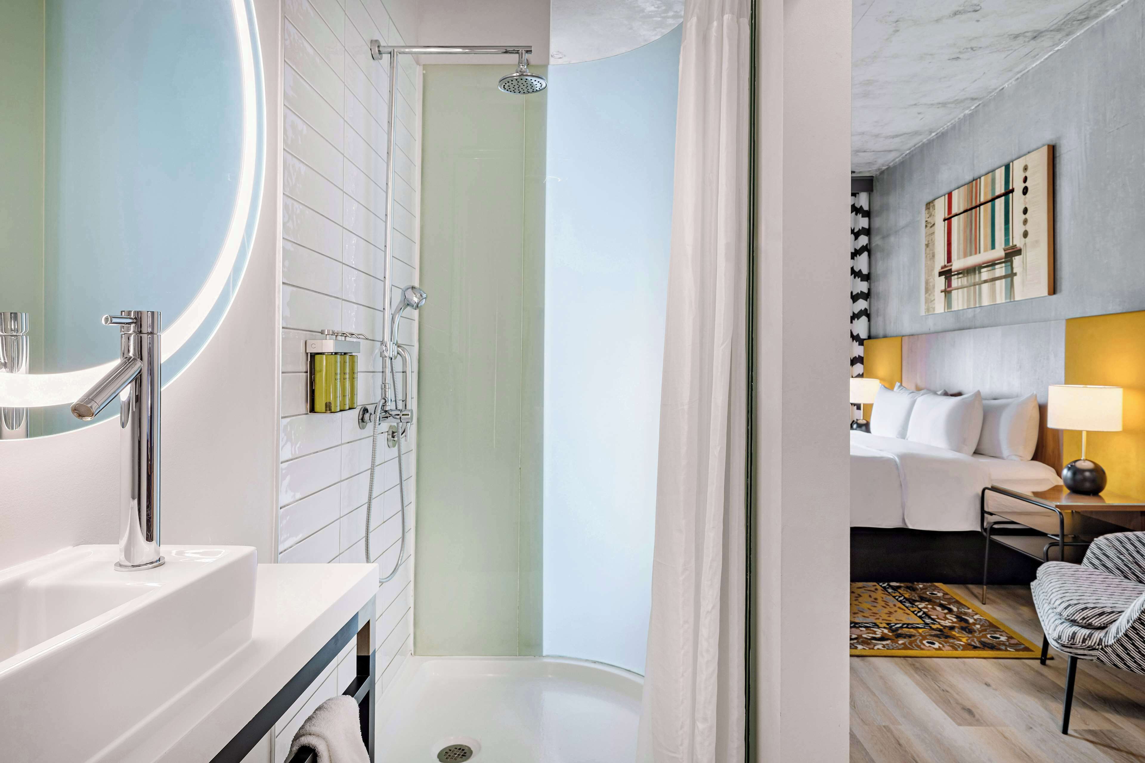 Un baño moderno con ducha, lavamanos y espejo.