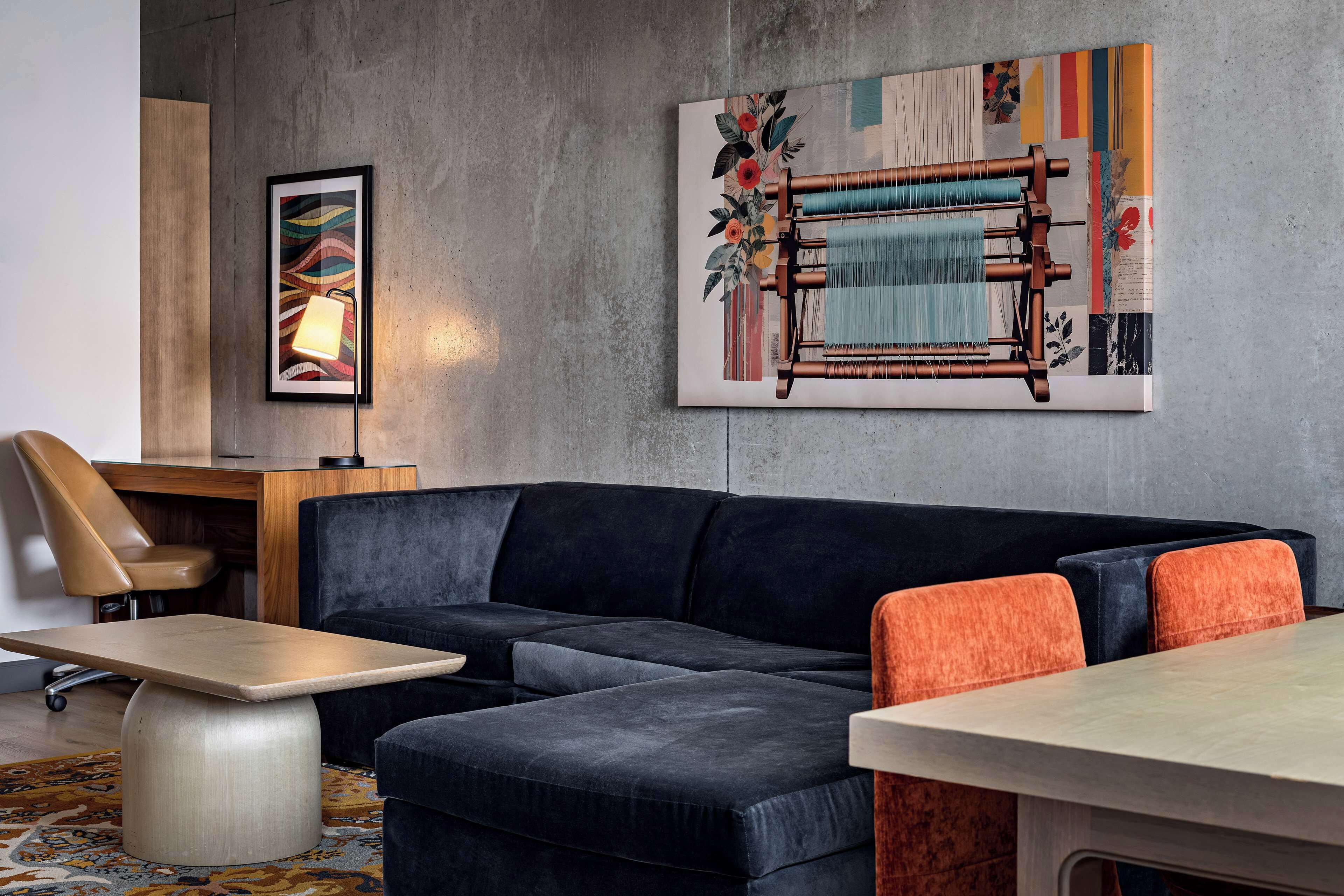 Een moderne woonkamer met een modulaire bank, een bijzettafeltje en een wandweefgetouw.