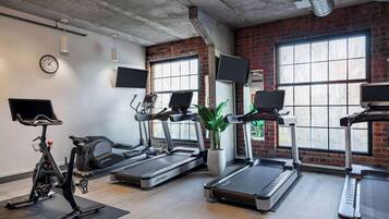 A gym with treadmills, a stationary bike, and a large window with a view.