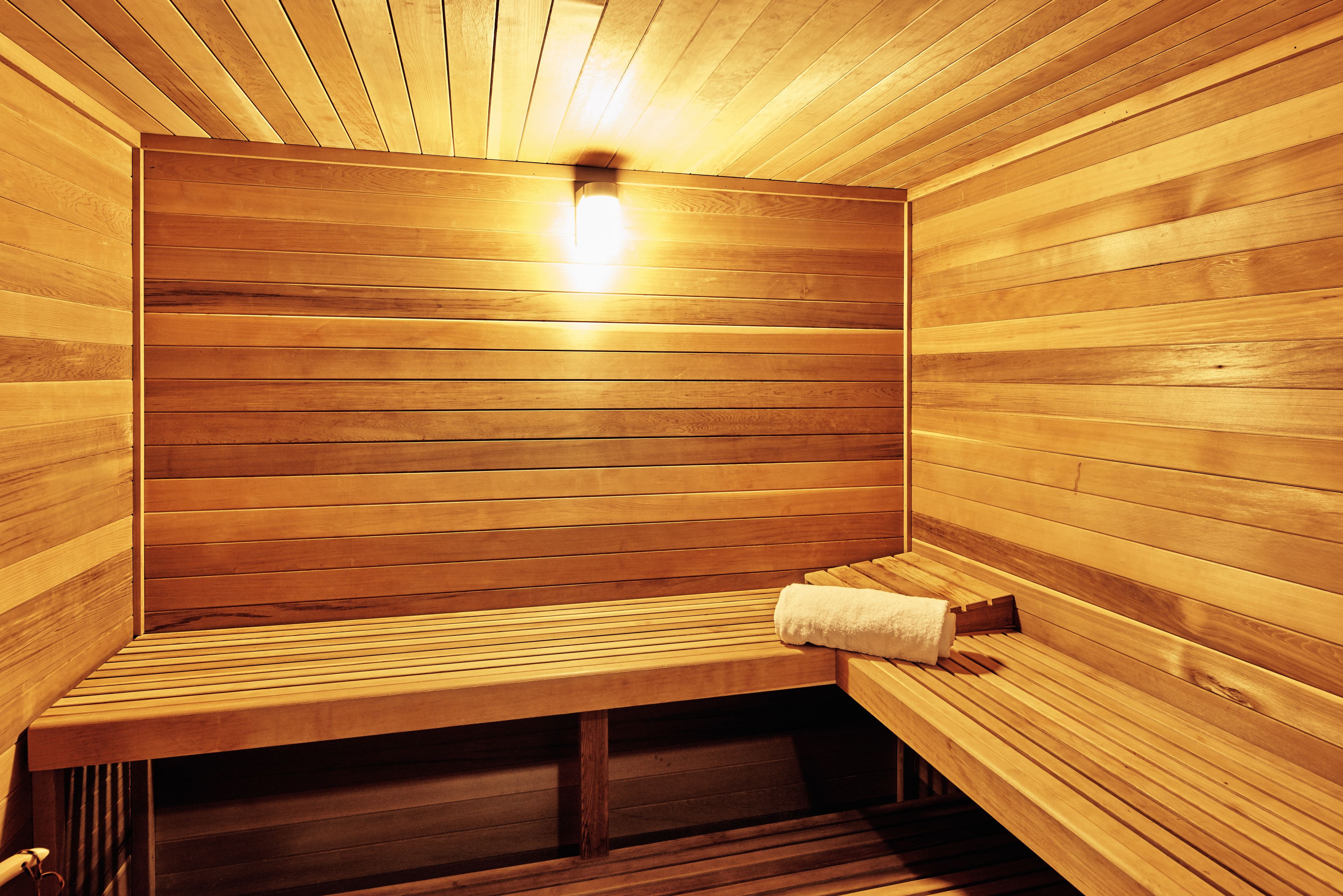 Una sauna de madera con bancos y un perchero para toallas.