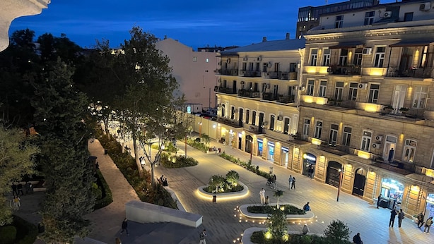 A spacious courtyard with modern architecture, surrounded by trees and illuminated pathways. - Baku Center inn (Baku)