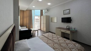 A hotel room with a bed, a desk, a television, and a wardrobe. - Baku Center inn (Baku)