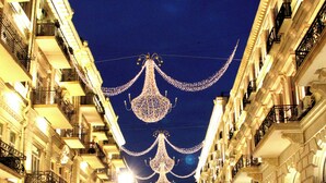 A busy urban street at night with illuminated decorations and people walking. - Baku Center inn (Baku)