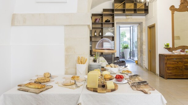Un comedor con una mesa de buffet que incluye queso, pan y diversos platos.
