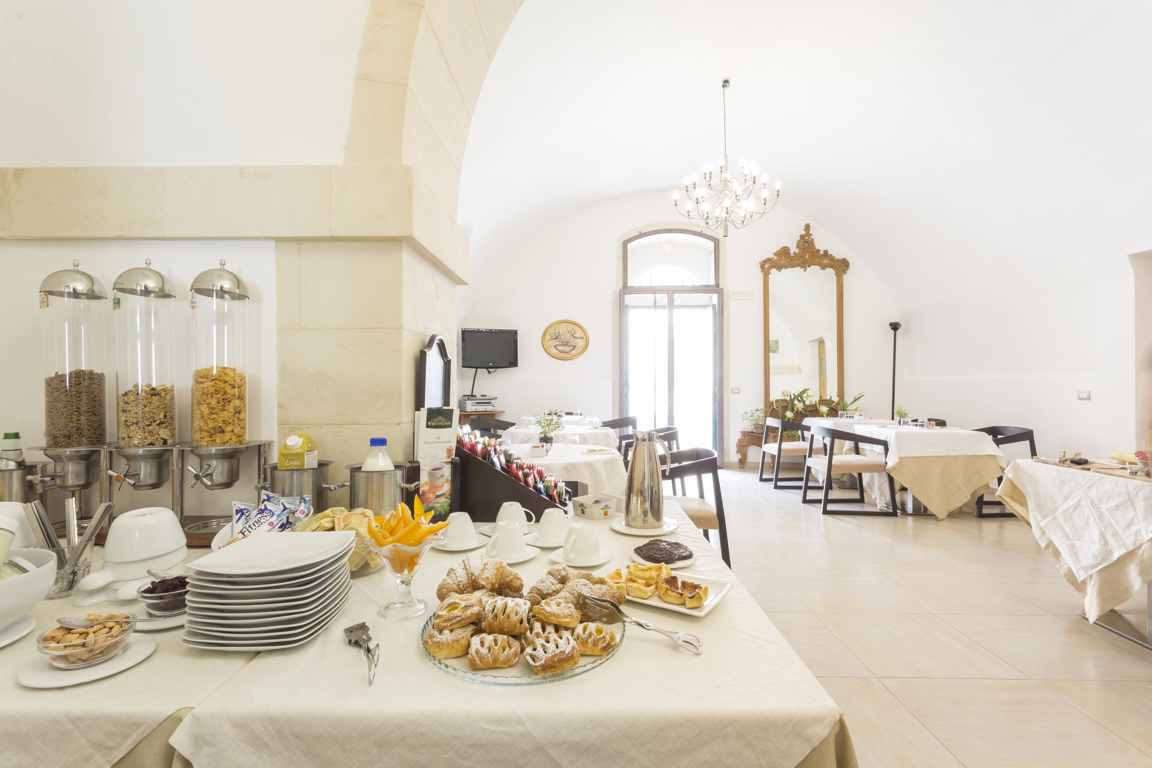 A dining area with a buffet setup, including various food items and serving utensils.