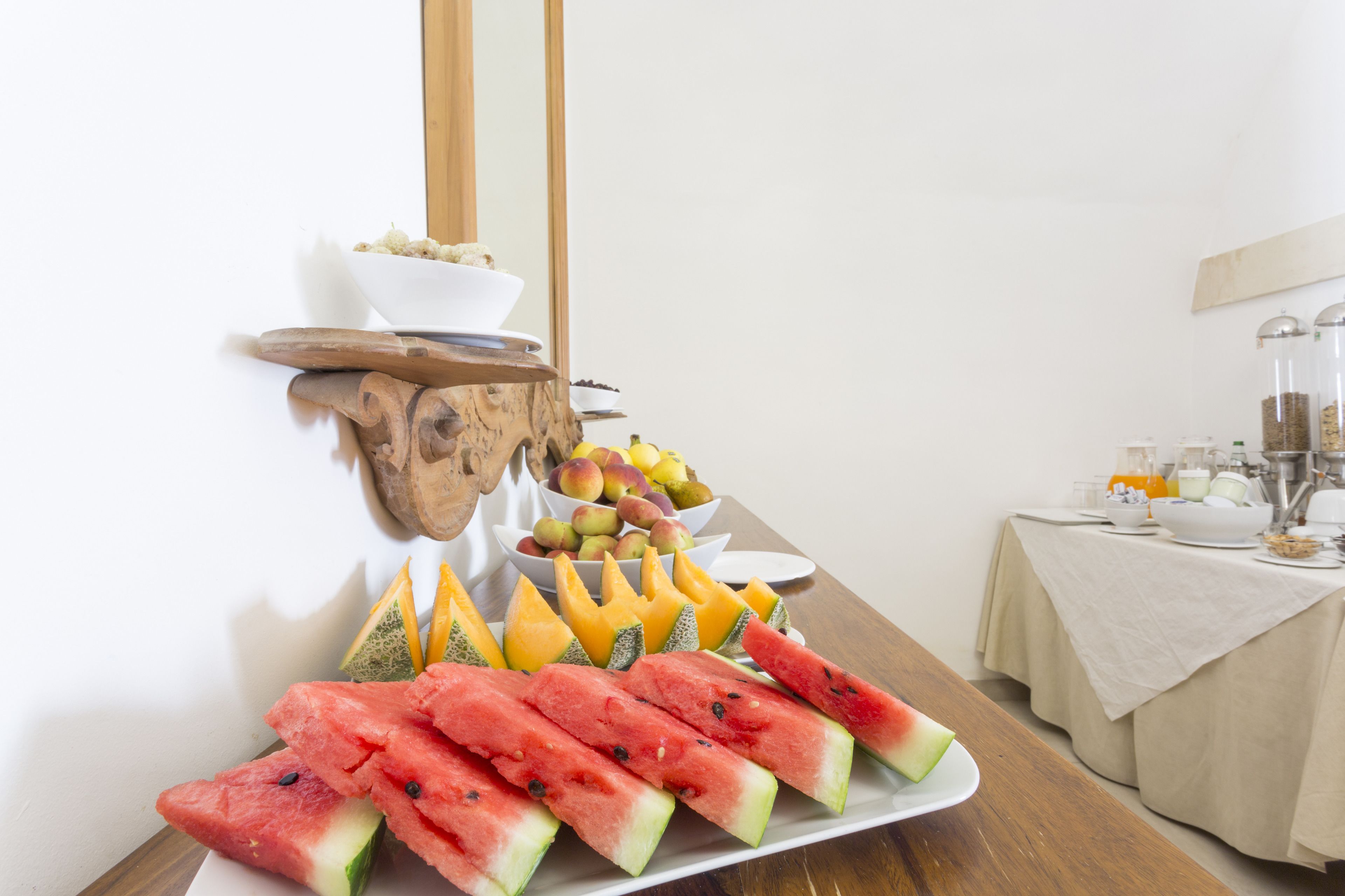 Un bufé de desayuno con diversas frutas y una estación de café.