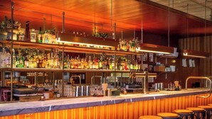 A bar area with a wooden ceiling, a disco ball, and multiple stools. - The Standard East Village (New York)