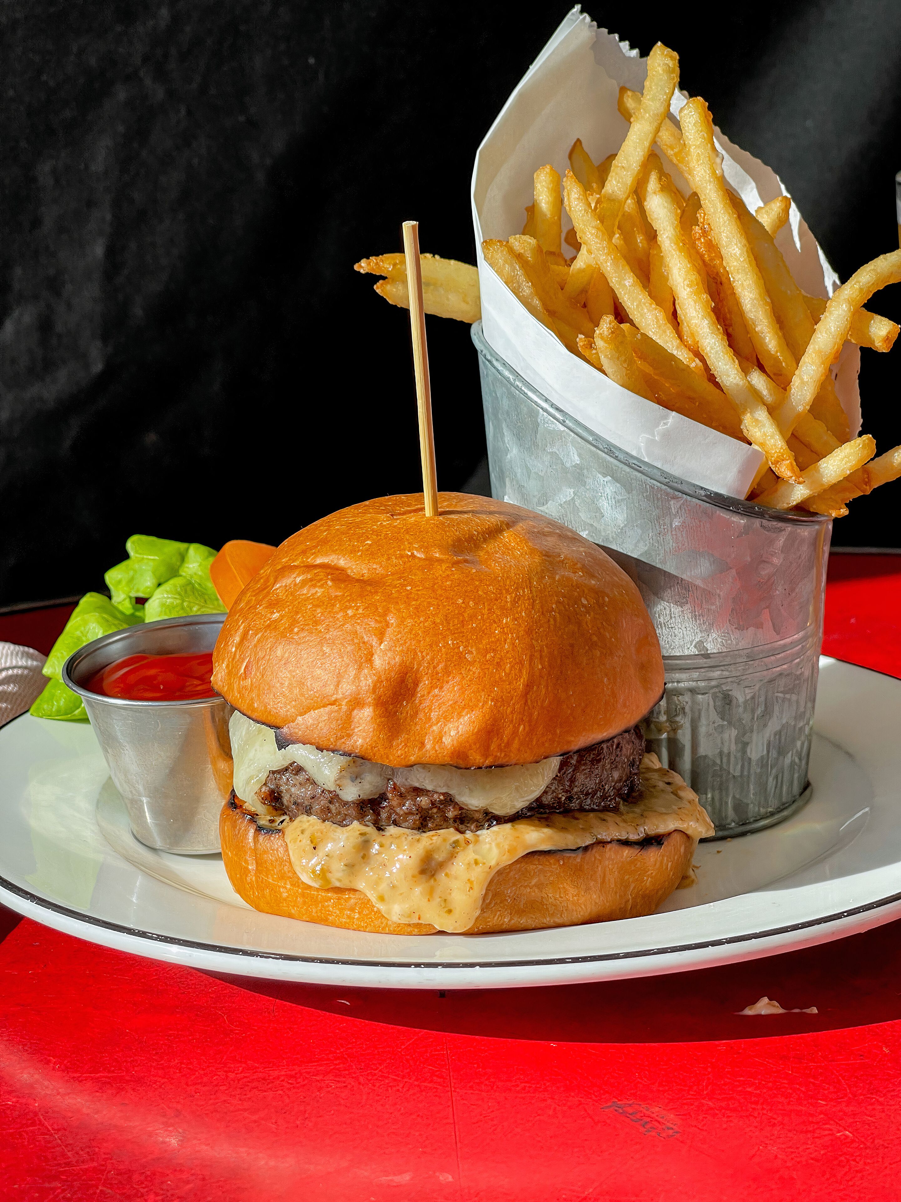 Un hamburger con patatine fritte e ketchup su un piatto.