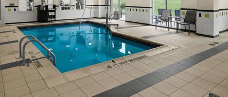 Una piscina con socorrista, vestuarios y zona de estar con vistas al exterior.