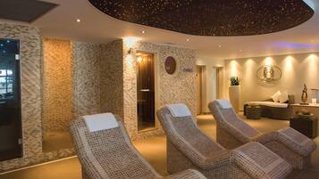 Een spa-ruimte met drie ligstoelen, een massagetafel en een plafond met sterrenmotief.