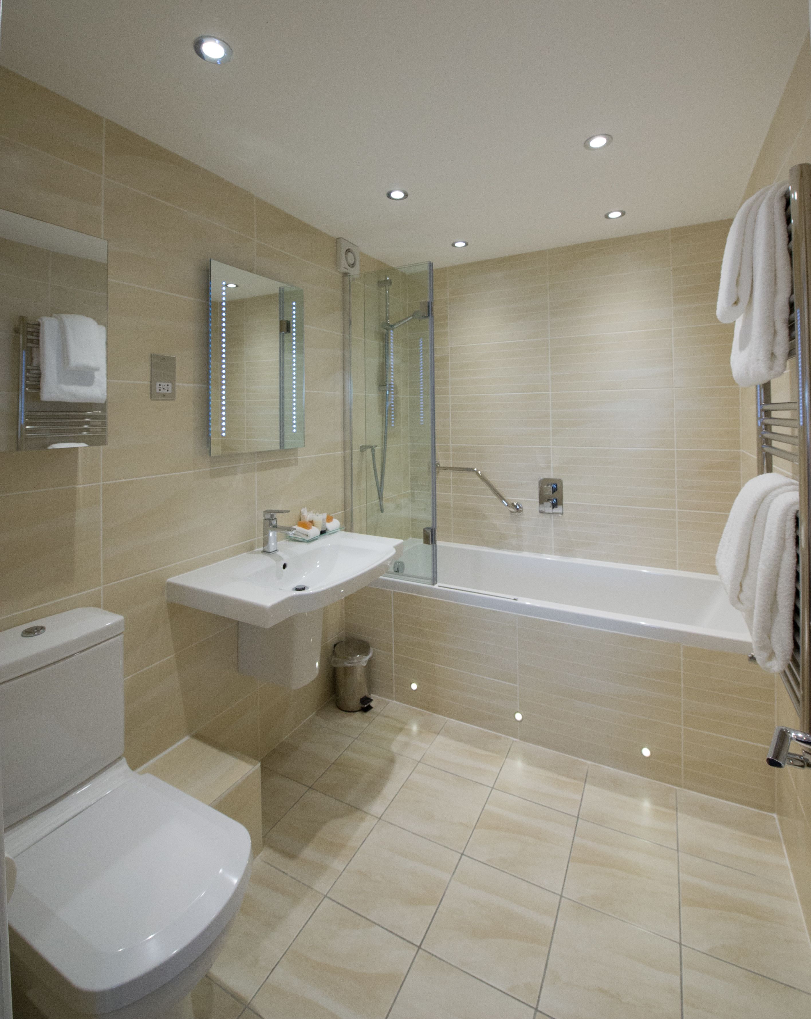A modern bathroom with a toilet, sink, and bathtub.